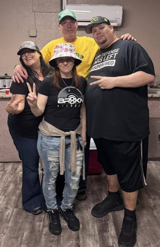 Four people including Jenna Marie in BR8KN Records shirt at the Florida underground show May 2026