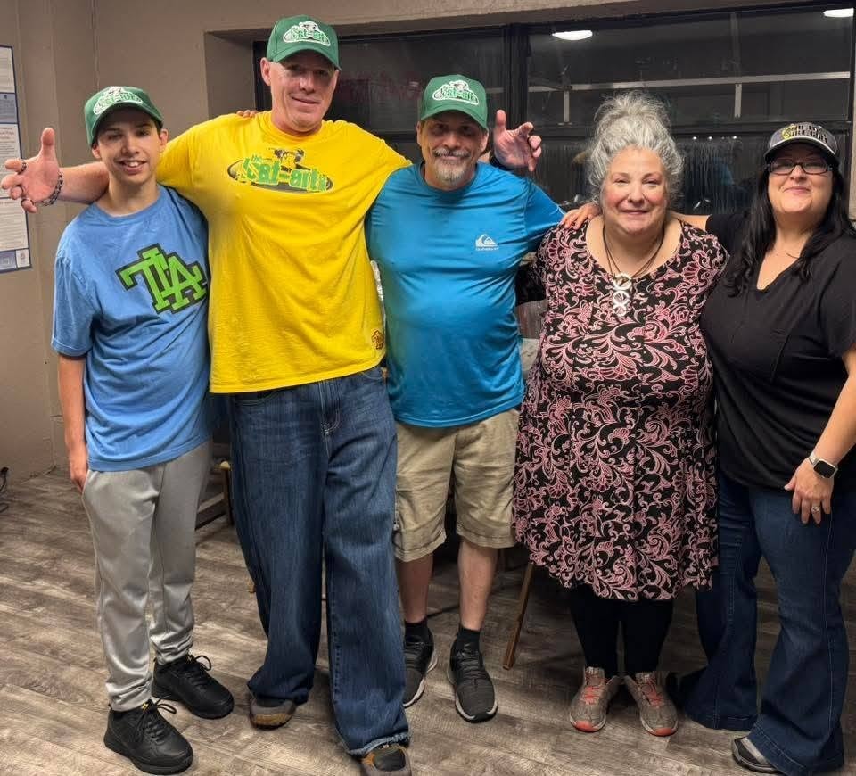 Five people including DJ Natural Nate® wearing The-Lost-Art.com green caps at the Florida underground show May 2026