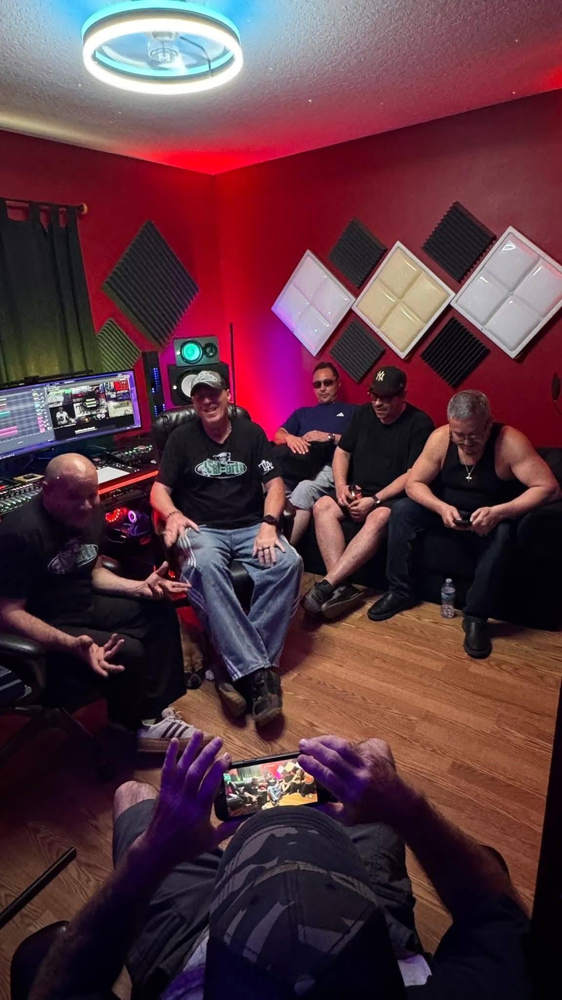 DJ Natural Nate® and five friends inside a professional recording studio with red lighting at the Florida show May 2026