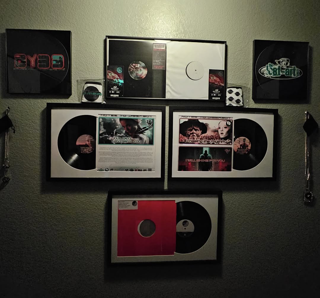 The proud record wall, DJ Natural Nate® vinyl releases including the Notes to Jiggabot EP, BYBB releases, and The-Lost-Art.com records, all framed and displayed